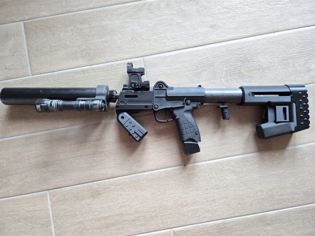 A KelTec SDP fitted with a rail, fore-grip and butt-stock, suppressed, with a red dot optic
